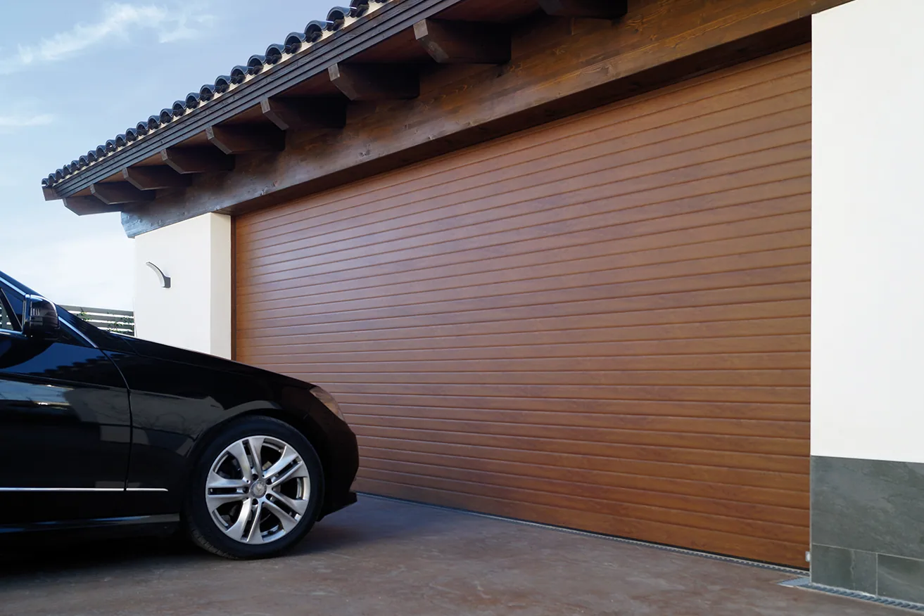 Portón enrollable de aluminio símil madera Luxe Perfil instalado en una vivienda